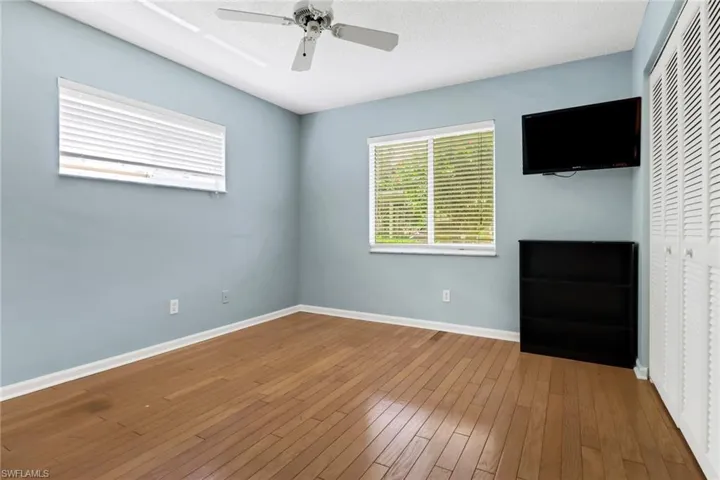 Unfurnished bedroom featuring a closet, hardwood / wood-style flooring, ceiling fan, and a textured ceiling