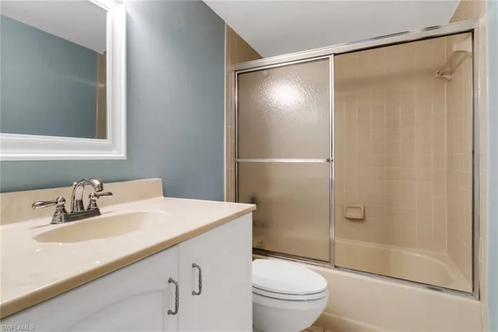 Full bath with vanity and combined bath / shower with glass door