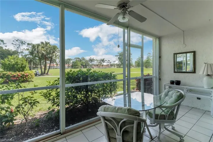 Sunroom featuring golf course view and ceiling fan