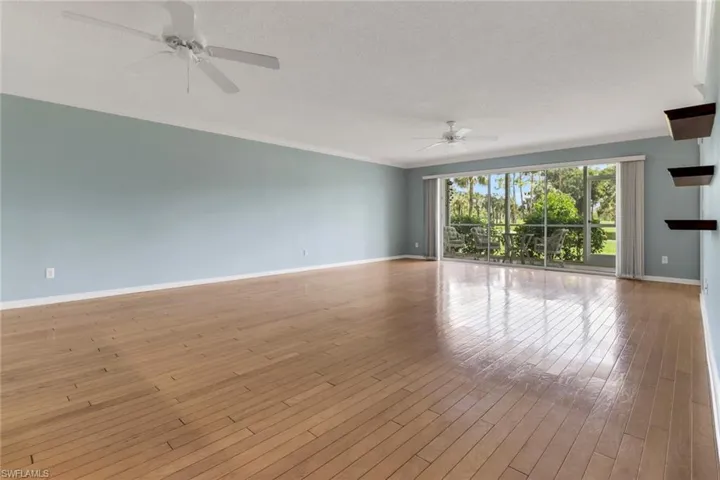 Unfurnished room featuring a ceiling fan, a textured ceiling, hardwood / wood-style flooring, and crown molding