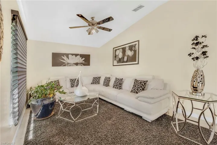 Living room with a ceiling fan and vaulted ceiling