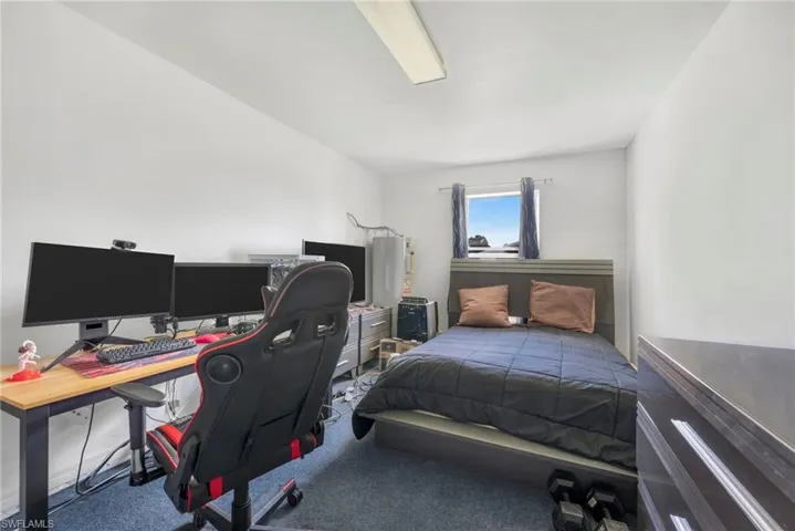 Carpeted bedroom with a desk