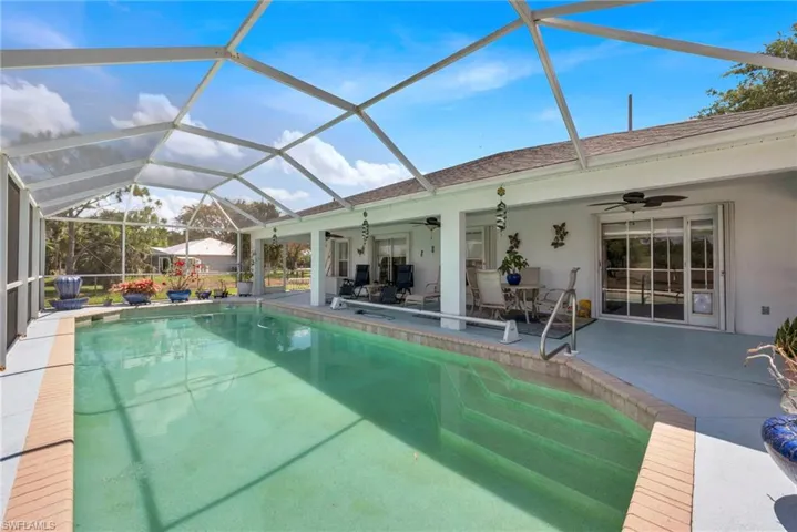 Outdoor pool featuring a sunroom, a patio area, a lanai, and outdoor dining space