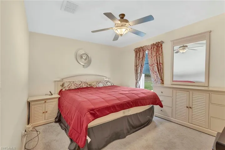 Bedroom with light colored carpet and a ceiling fan