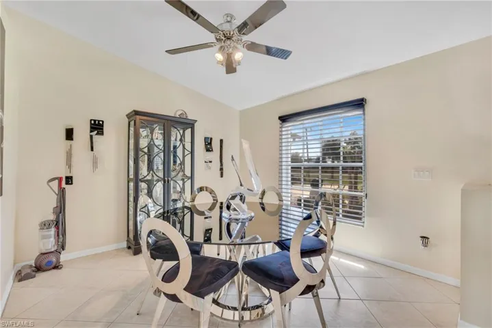 Dining space with light tile patterned floors and a ceiling fan