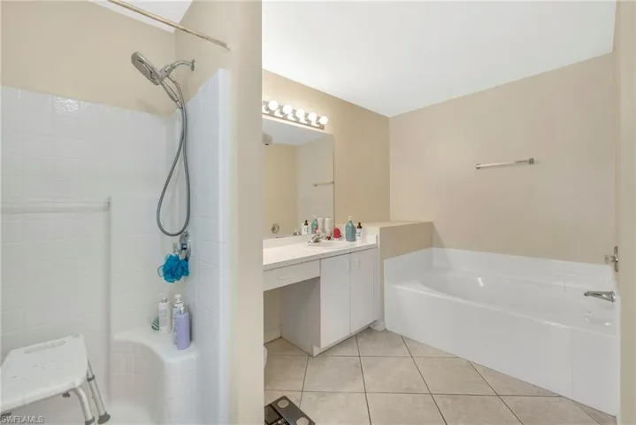 Full bath with light tile patterned flooring and vanity