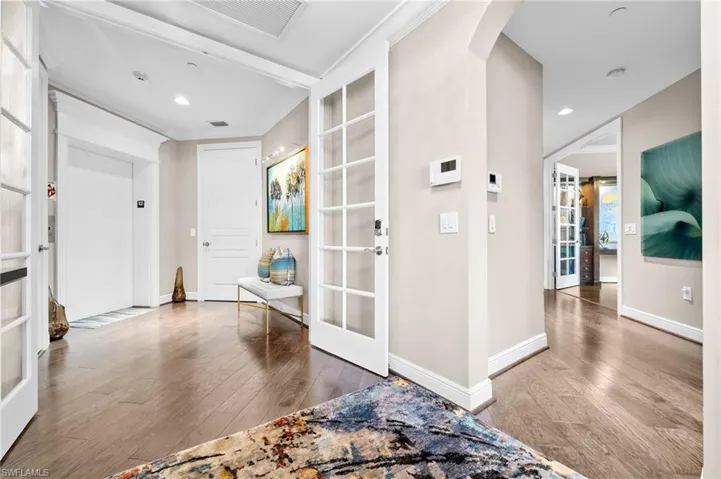 Foyer with elevator, recessed lighting, french doors, light wood finished floors, and ornamental molding