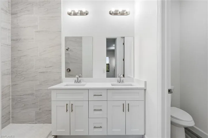 Bathroom with double vanity and a tile shower