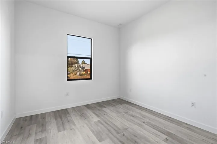 Spare room featuring light wood-style floors and baseboards