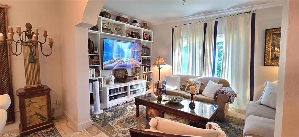 Living area with crown molding and baseboards