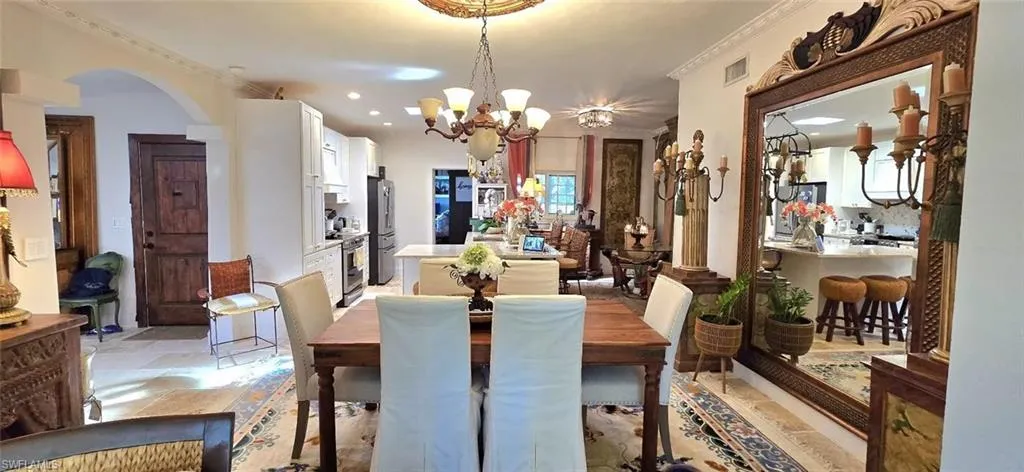Dining room featuring arched walkways, a chandelier, healthy amount of natural light, and recessed lighting