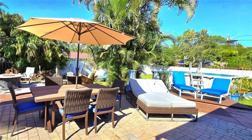 Fenced backyard with a patio, outdoor dining space, and an outdoor fire pit