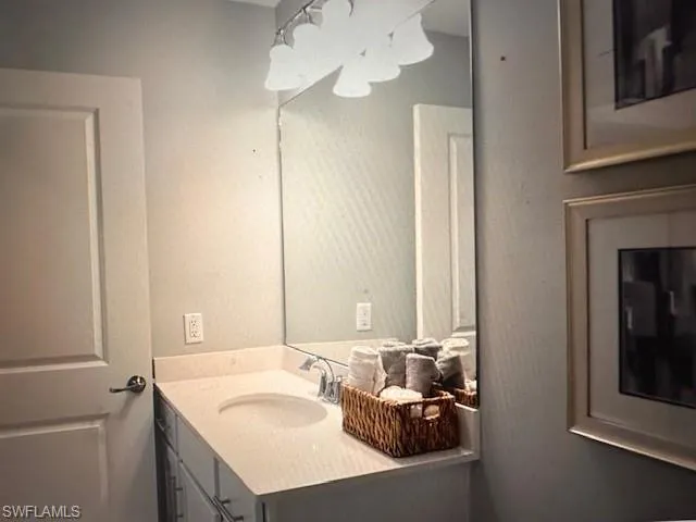 Bathroom featuring vanity, toilet, an enclosed shower, and ceiling fan
