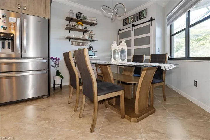 Dining space with a barn door and ornamental molding