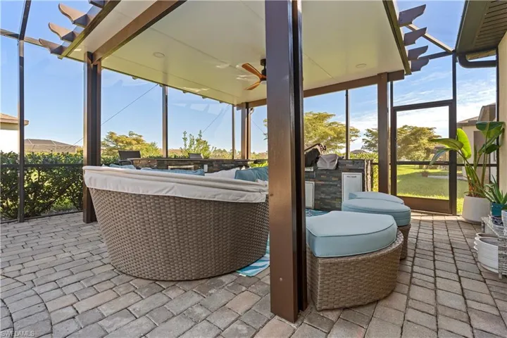View of patio with a sunroom, a lanai, ceiling fan, and exterior kitchen