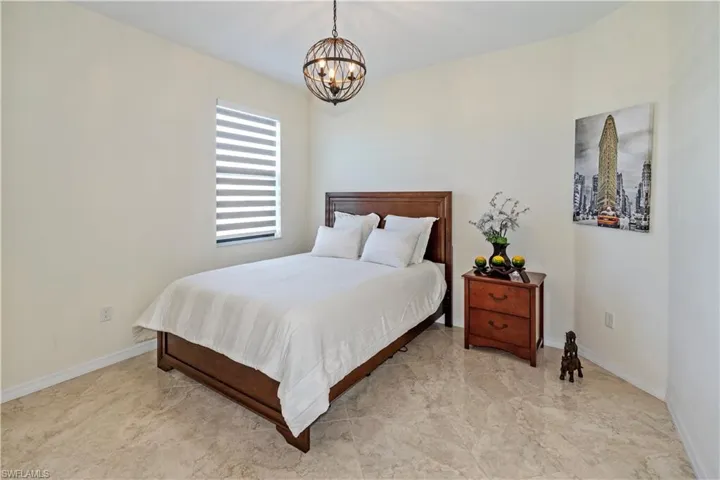 Bedroom featuring baseboards and a chandelier