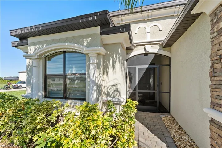 Property entrance featuring a sunroom and stucco siding