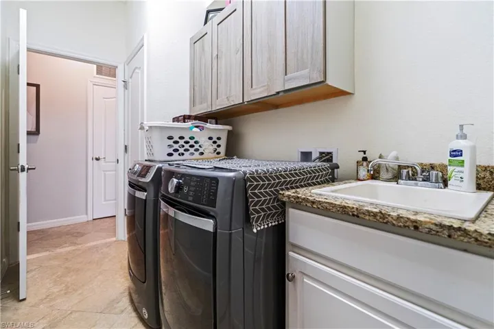 Laundry room with independent washer and dryer and cabinet space