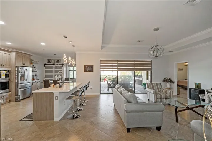 Living area with a chandelier, crown molding, and recessed lighting