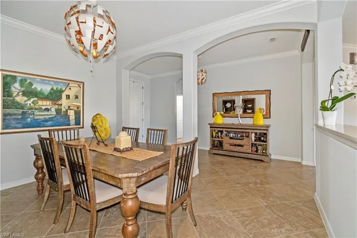 Dining space with arched walkways and crown molding