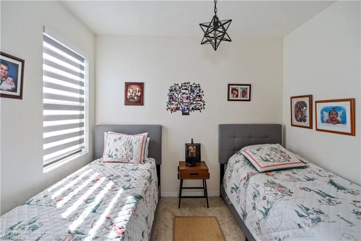 Bedroom featuring multiple windows and light carpet