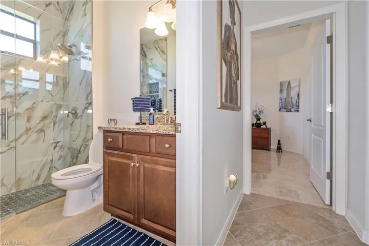 Full bathroom with vanity and a marble finish shower