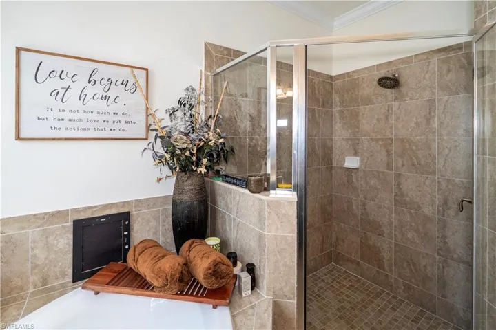 Full bath featuring a stall shower, ornamental molding, and a garden tub
