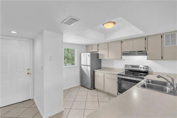 Kitchen featuring stainless steel appliances, light countertops, and light tile patterned floors