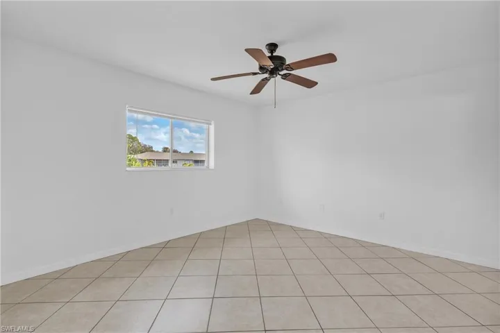 Empty room featuring a ceiling fan and light tile patterned floors