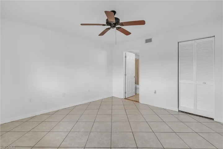 Unfurnished bedroom with a ceiling fan, a closet, and light tile patterned floors
