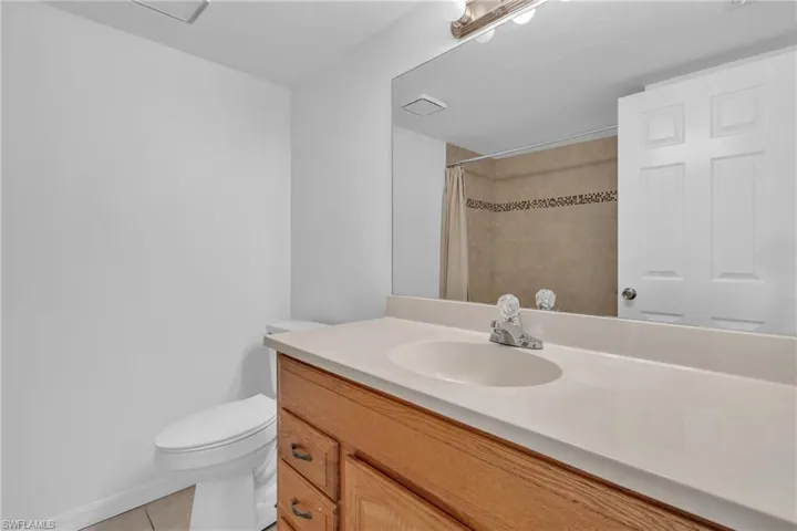 Bathroom featuring vanity, curtained shower, and light tile patterned floors