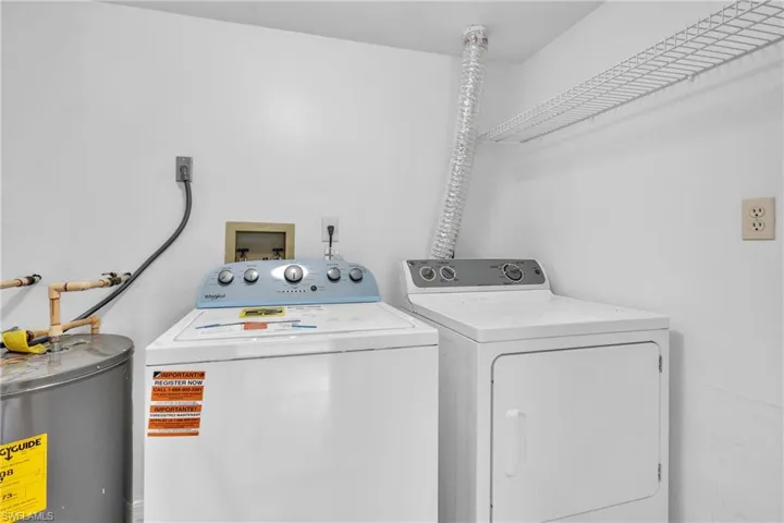 Laundry room with water heater and separate washer and dryer