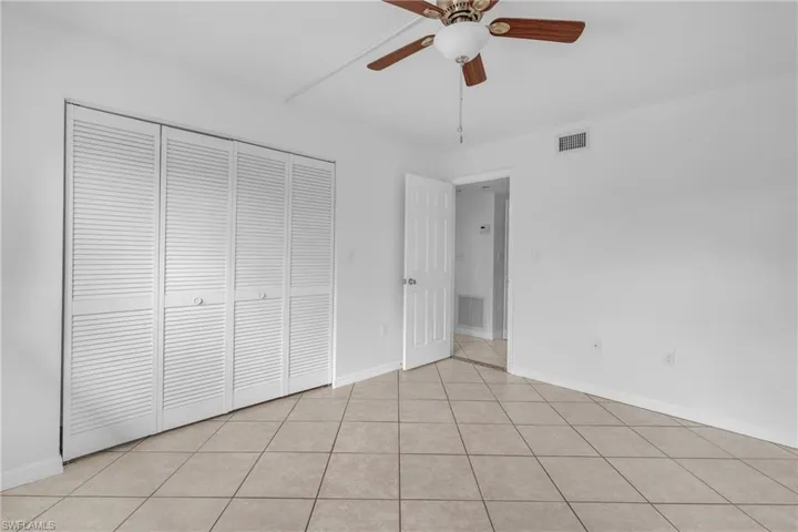 Unfurnished bedroom with a ceiling fan, a closet, and light tile patterned floors