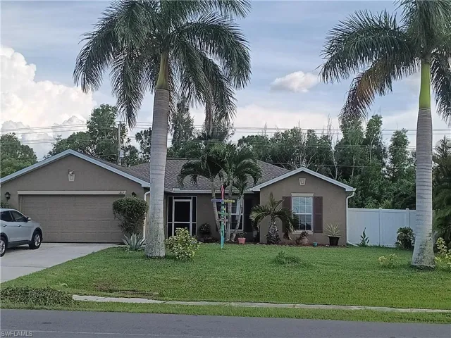 Ranch-style house with a garage and a front lawn