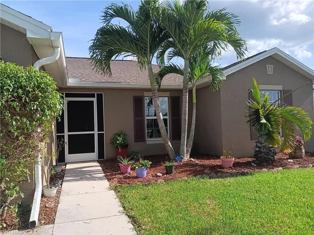 View of exterior entry with a lawn