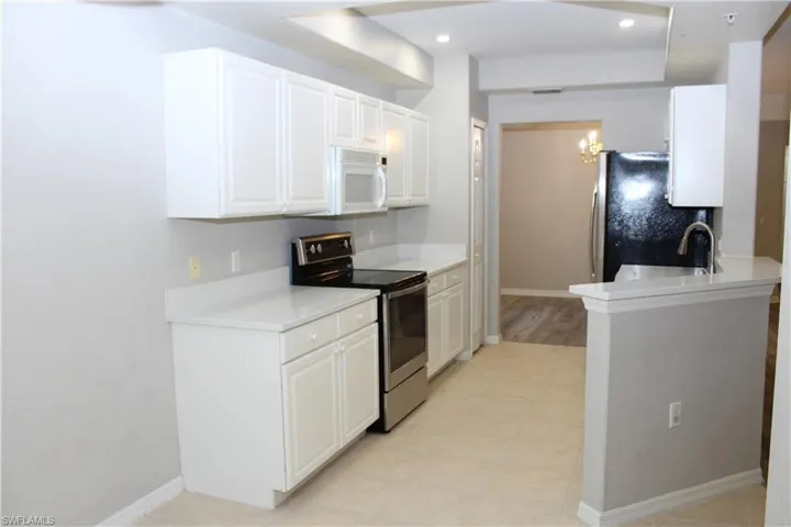 Kitchen with white cabinetry, sink, appliances with stainless steel finishes, and light tile patterned floors
