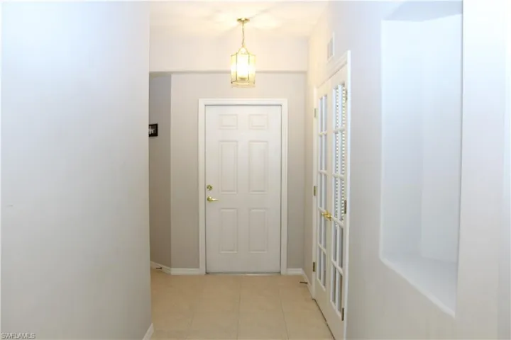 Doorway with light tile patterned floors