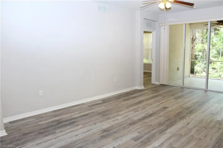 Spare room with wood-type flooring, ceiling fan, and plenty of natural light