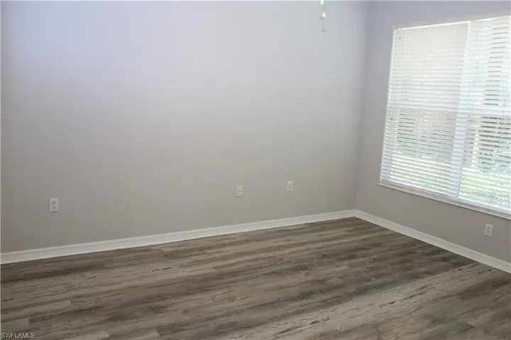 Empty room featuring dark wood-type flooring