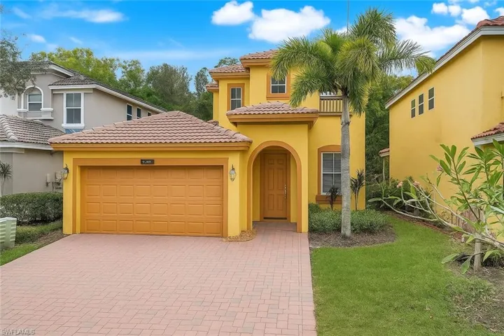 Mediterranean / spanish home featuring stucco siding, a tiled roof, decorative driveway, and a front lawn