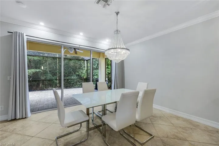 Dining space featuring ornamental molding, light tile patterned floors, a chandelier, and recessed lighting