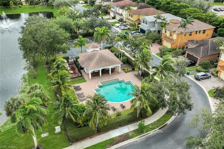 Aerial perspective of suburban area with a nearby body of water and a pool