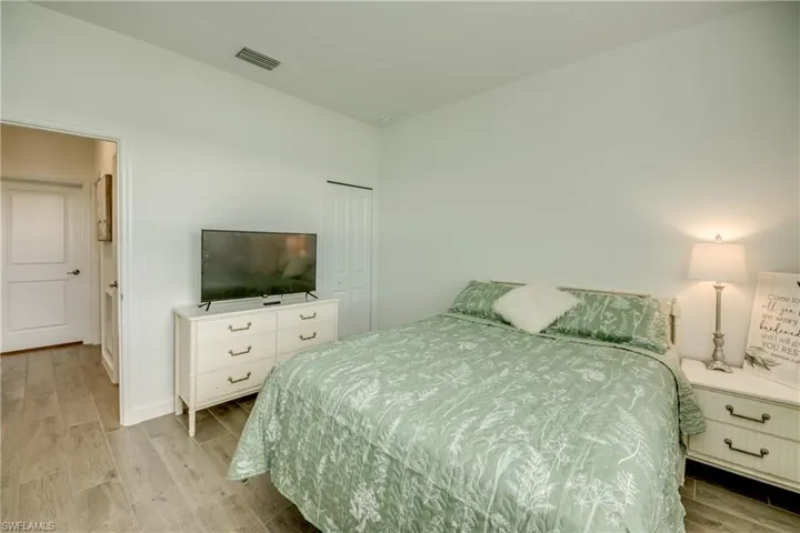 Bedroom featuring wood finish floors and a closet