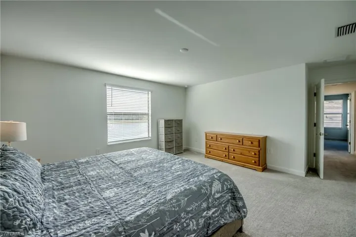 Bedroom with light carpet and baseboards