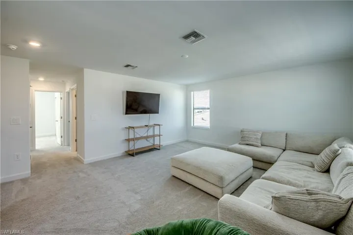 Carpeted living area with baseboards