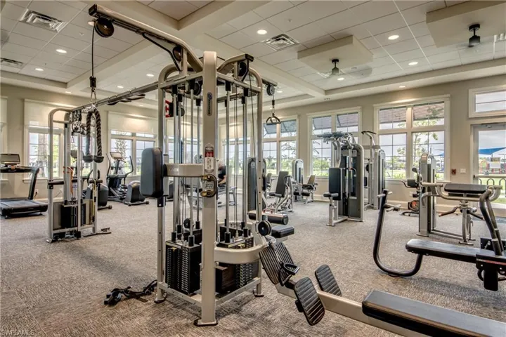 Gym with a drop ceiling, a high ceiling, and recessed lighting