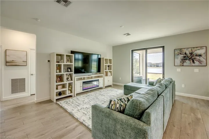 Living room with light wood-type flooring and a glass covered fireplace