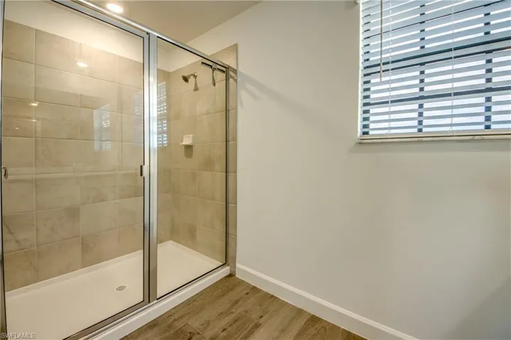 Bathroom featuring a shower stall and wood finished floors