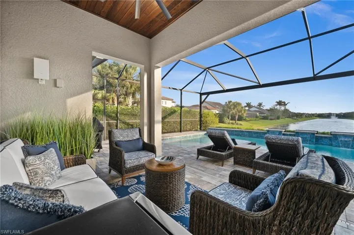 View of patio featuring an outdoor living space, pool water feature, ceiling fan, a water view, and glass enclosure