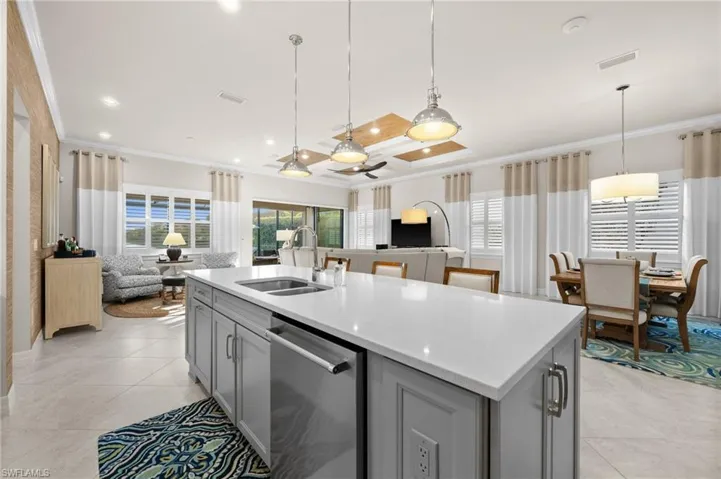 Kitchen with dishwasher, gray cabinets, crown molding, and sink